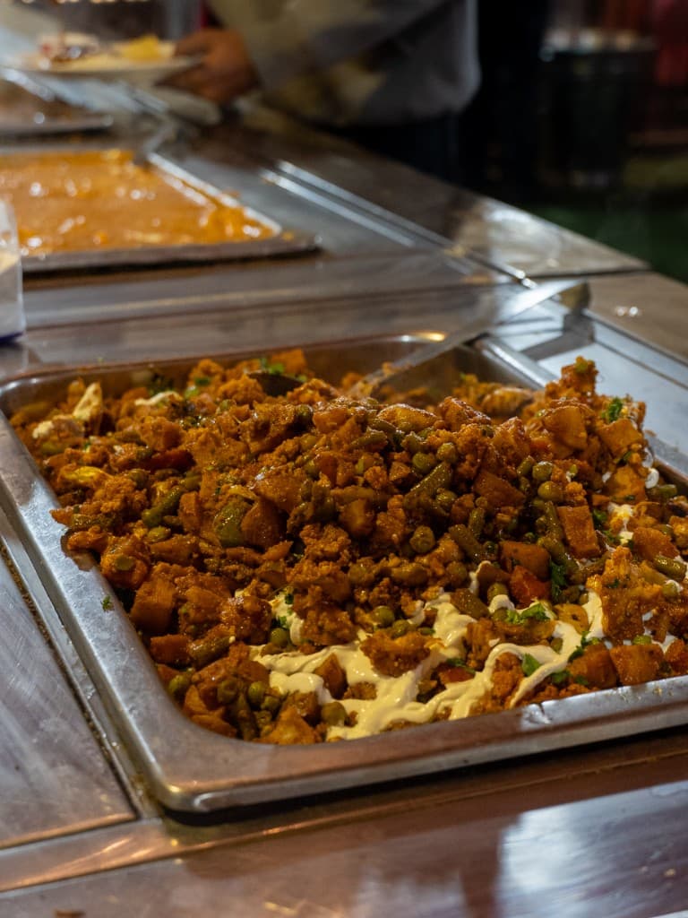 Decorative brass vases and flower arrangements at wedding buffet